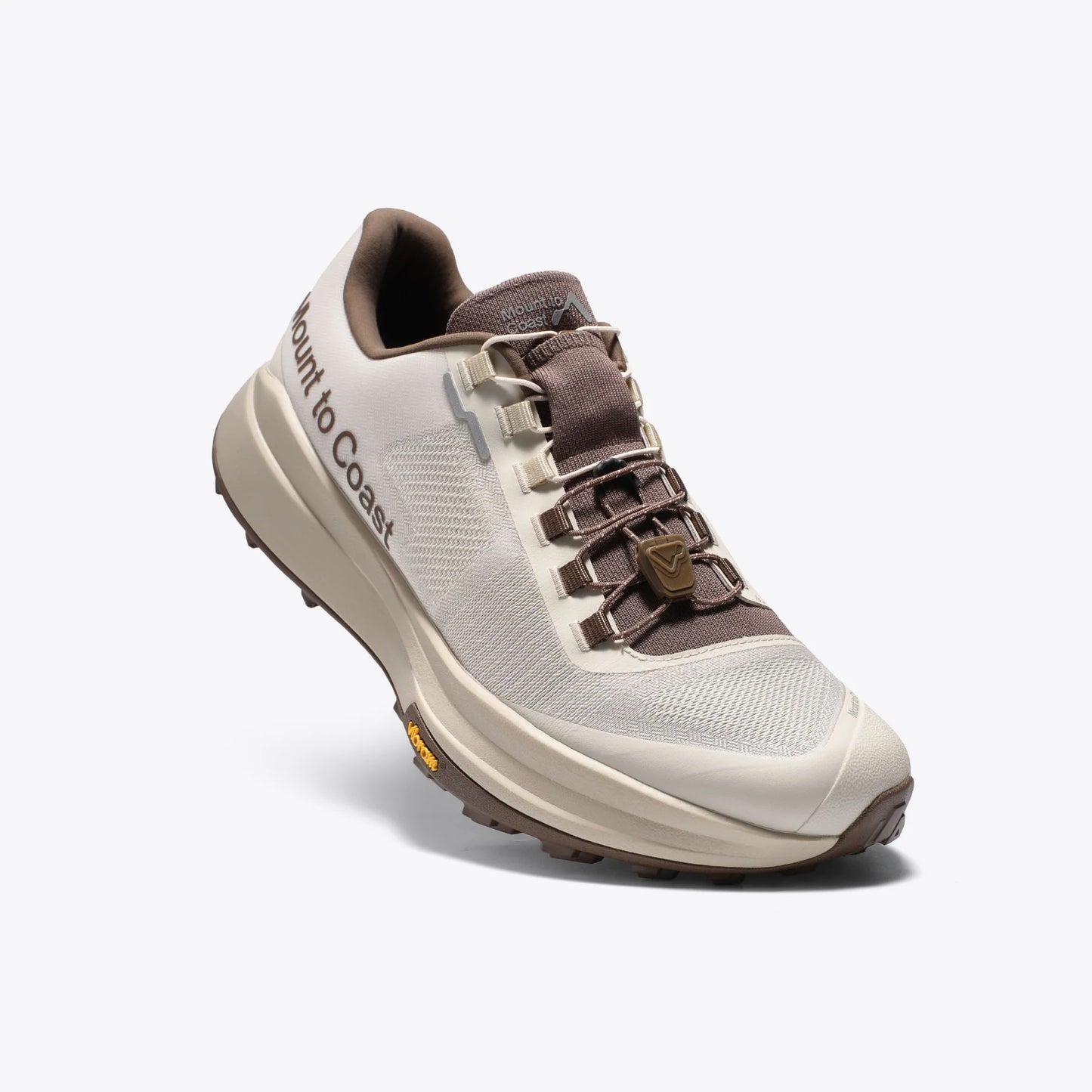Mount to Coast T1 trail running shoe in beige and brown colorway, featuring Vibram outsole and brand name on the side.
#Color_dune