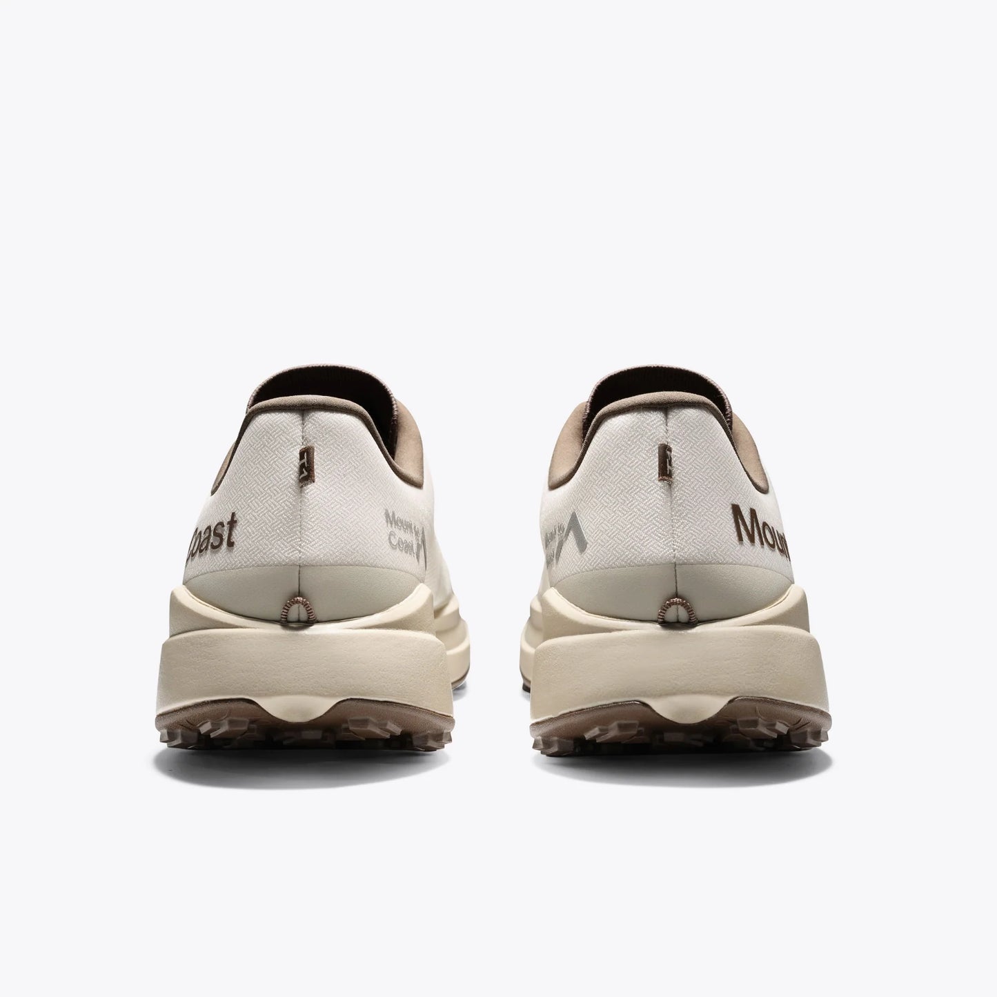 Mount to Coast T1 trail running shoes rear view. Beige and brown colorway. Brand logo and design detail on the heel.
#Color_dune